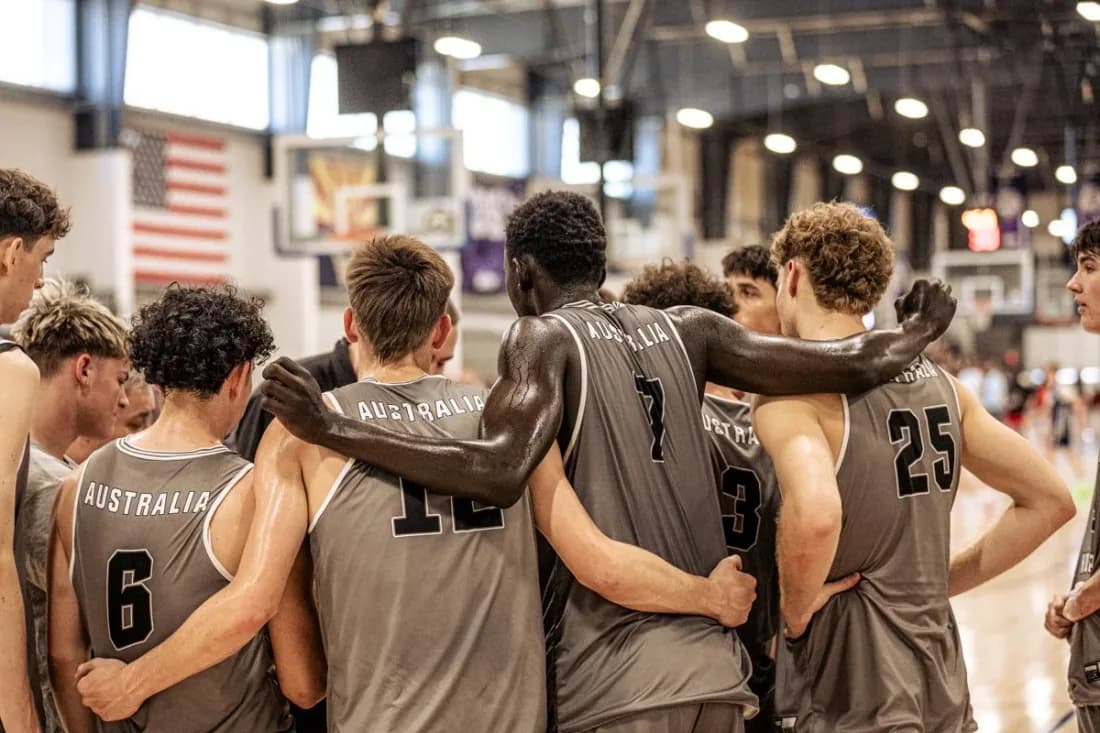An AUSA Hoops team huddled arm-in-arm