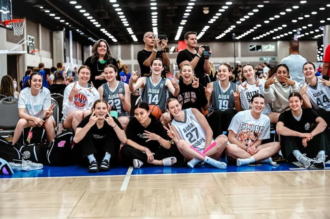 An AUSA Hoops team celebrating together courtside